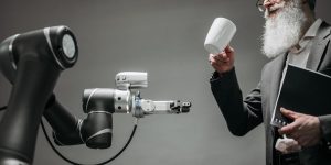 A humanoid robot hand shaking a human hand representing accountability and collaboration in 2026