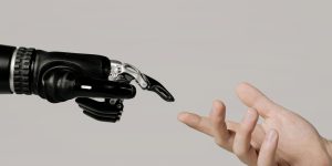 A detailed close-up of a human hand touching a robotic hand, representing the biological moat in an AI-driven world.