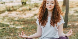 A person sitting in nature, reflecting on human autonomy and digital minimalism in a world dominated by AI.