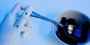 Humanoid robot working at a laptop in a modern office environment, symbolizing the unbundling of traditional roles.