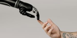 A robotic hand shaking a human hand representing somatic integrity